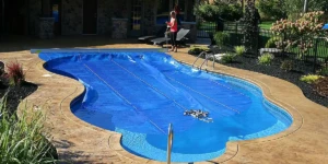 Lady covering pool with ClearDeck solar blanket