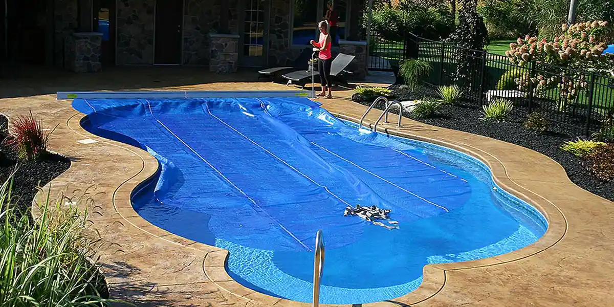 Lady covering pool with ClearDeck solar blanket