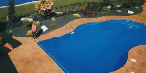 Slight overhead angle of lady opening her pool cover New York