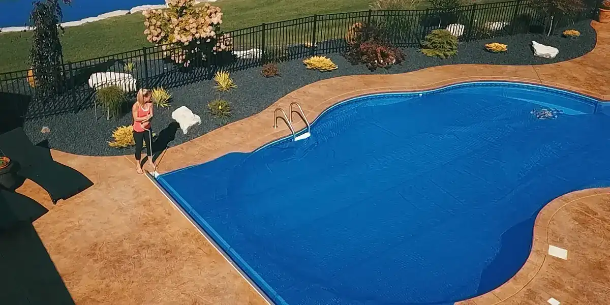 Slight overhead angle of lady opening her pool cover New York